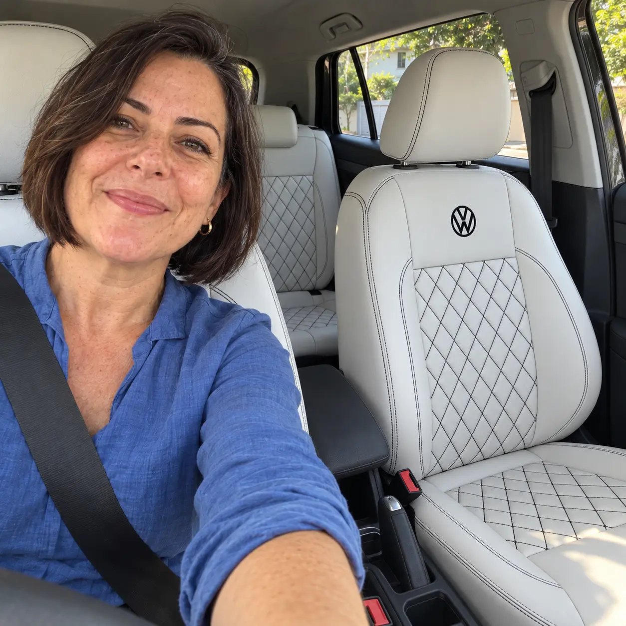 Cliente de camisa azul no Volkswagen T-Cross com bancos brancos diamantados, costura e logo pretas